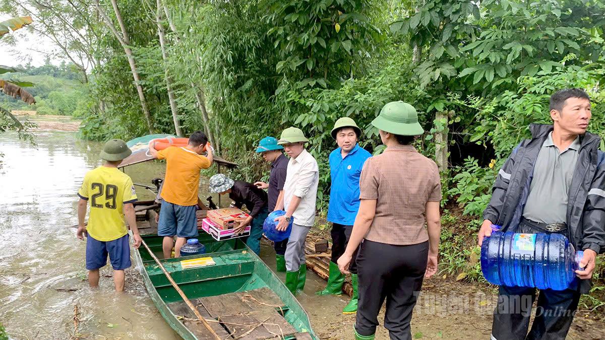 Lực lượng chức năng xã Hoà An vận chuyển nhu yếu phẩm nước uống tiếp tế cho người dân tại các thôn bị cô lập. Ảnh: Lý Thu