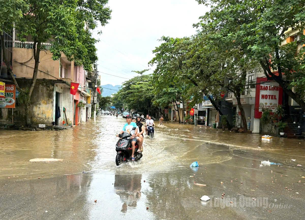 Đoạn đường Nguyễn Trãi tổ dân phố Tân Quang 15, phường Minh Xuân, nhiều người dân chủ quan ra xem nước. Ảnh Minh Thuỷ