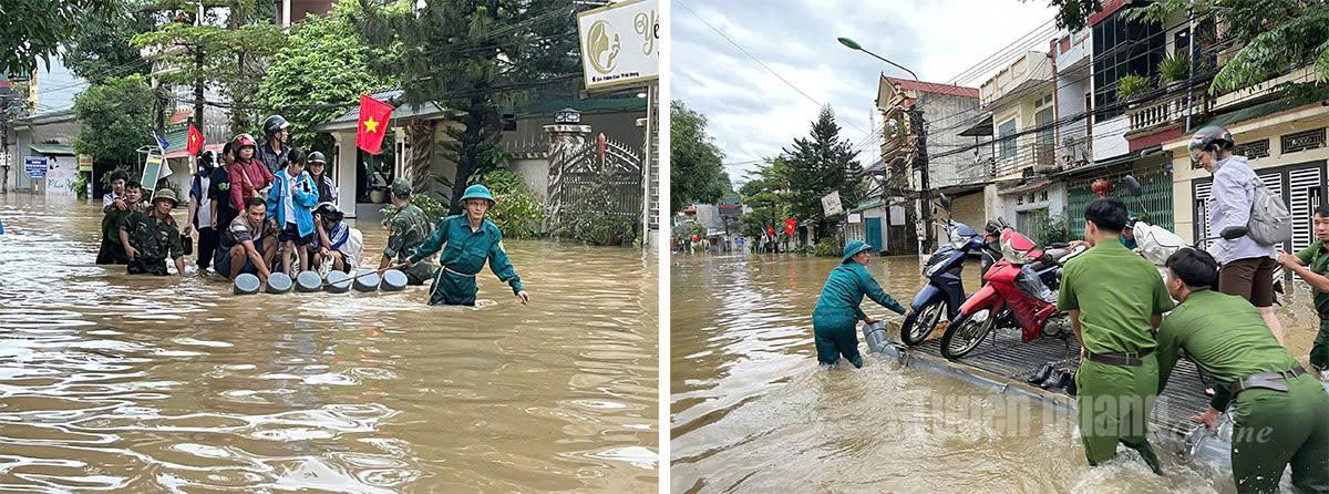 Lực lượng công an, quân sự hỗ trợ người dân di chuyển qua khu vực nước ngập cao tại phường Hà Giang 1. Ảnh: Thu Hằng