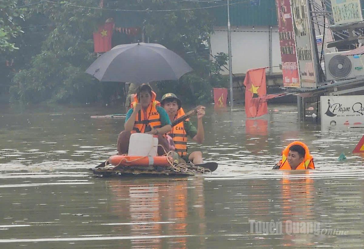 Nước dâng ngập khu vực đầu cầu chợ Xuân Vân, lực lượng công an khẩn trương hỗ trợ di dời người dân và tài sản đến nơi an toàn. Ảnh: Như Quỳnh