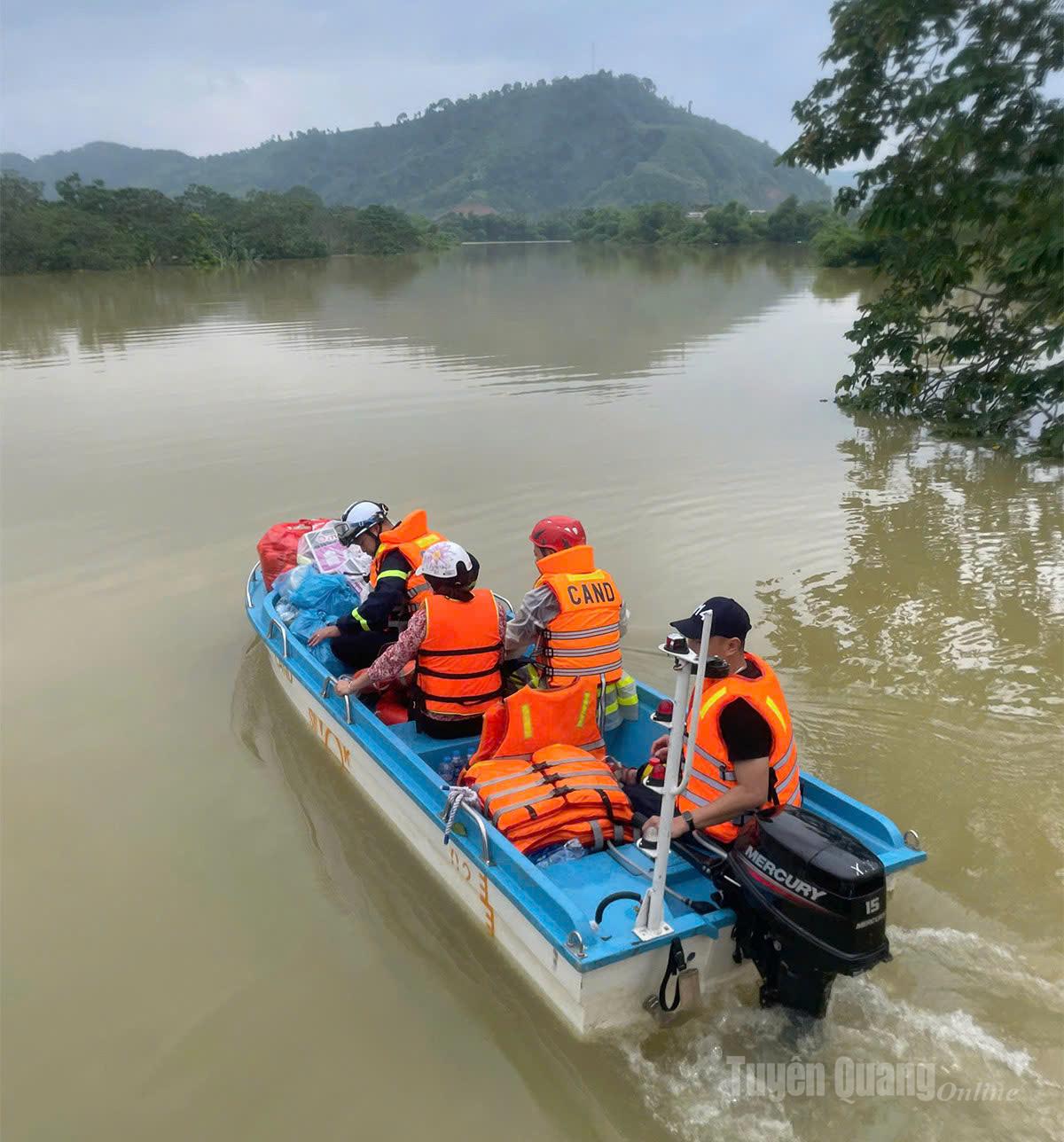 Đoàn công tác Cục Phòng cháy chữa cháy và Cứu nạn, cứu hộ (Bộ Công an), Công an thành phố Hà Nội phối hợp cùng Công an tỉnh Tuyên Quang thực hiện công tác hỗ trợ di chuyển người dân, tài sản đến nơi an toàn và vận chuyển, tiếp tế lương thực, nước uống cho người dân bị ảnh hưởng thiên tai tại thôn Tân Lâm, Tân Tiến, xã Tân Quang. Ảnh: Kỳ Dao.
