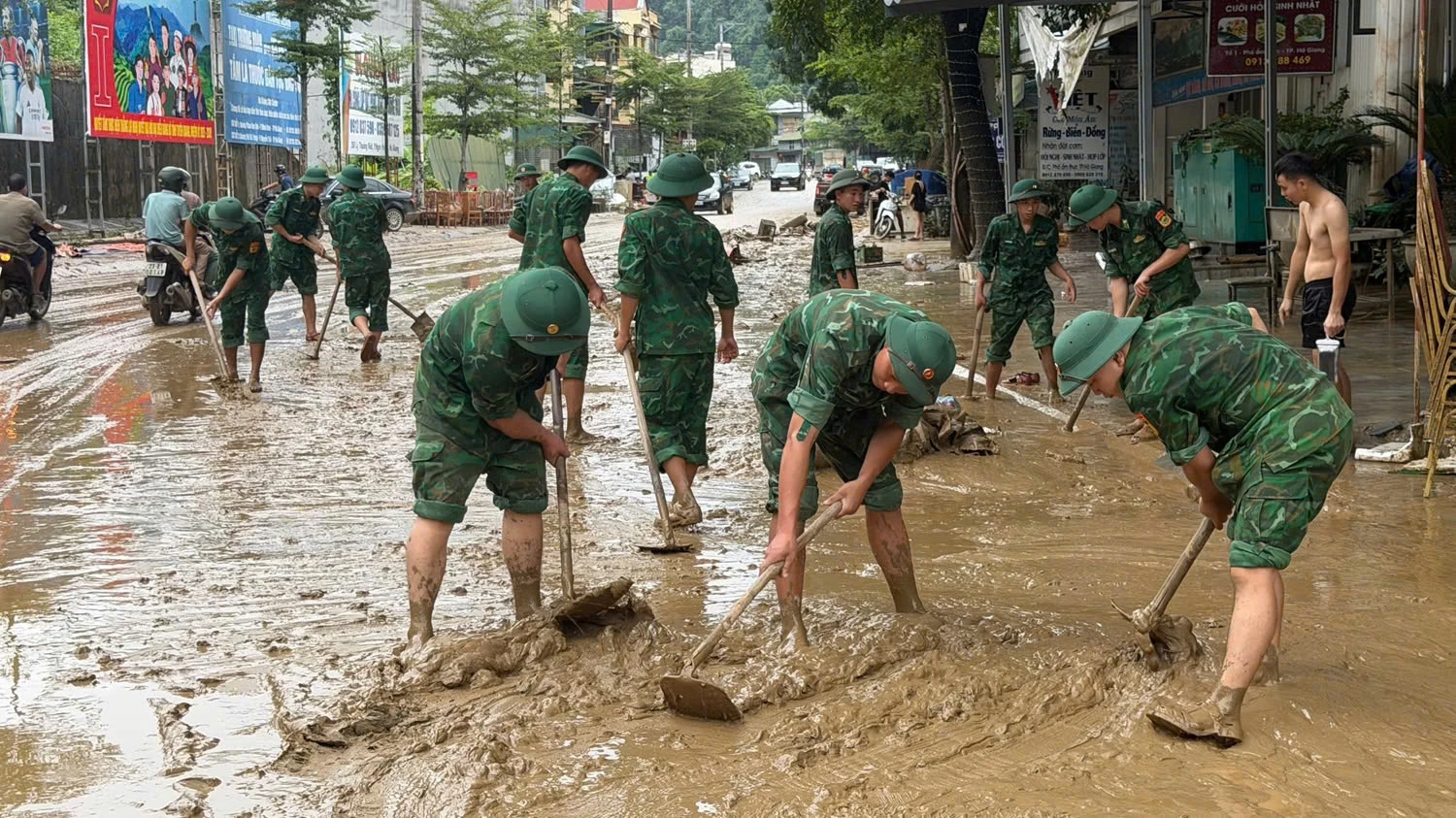 Đồn Biên phòng Cửa khẩu Quốc tế Thanh tế cử cán bộ chiến sĩ xuống hỗ trợ chính quyền và nhân dân phường Hà Giang 1 dọn dẹp khi nước lũ rút. (Ảnh: Thế Hà).