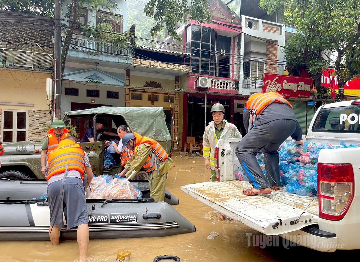 Lực lượng chức năng và người dân tích cực cứu trợ, cấp phát lương thực, nhu yếu phẩm thiết yếu cho bà con tại phường Hà Giang 2 bị nước lũ cô lập.                               Ảnh: Mộc Lan