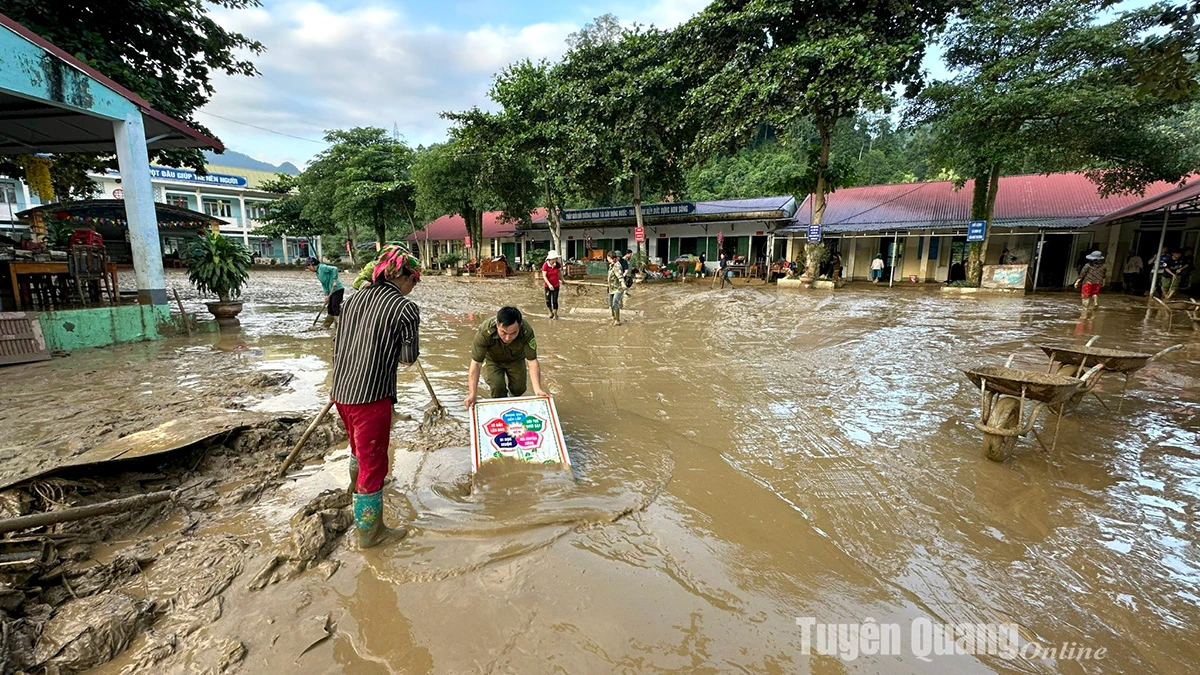 Thầy cô giáo Trường PTDTBT Tiểu học xã  Thuận Hoà phối hợp cùng Công an xã và người dân dọn dẹp bùn đất. Ảnh: Viên Sự
