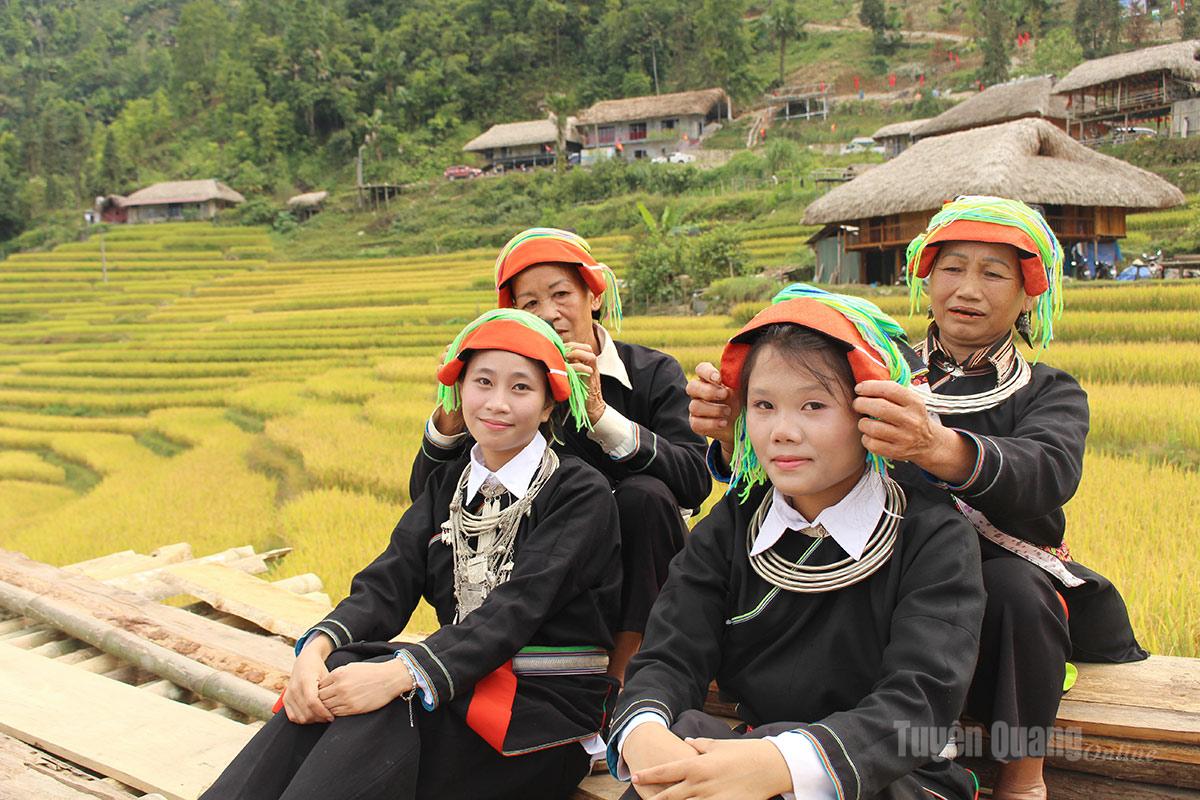 Những bà mẹ người Dao thôn Xà Phìn, xã Thanh Thủy chuẩn bị trang phục cho con tham dự lễ hội Mùa vàng.