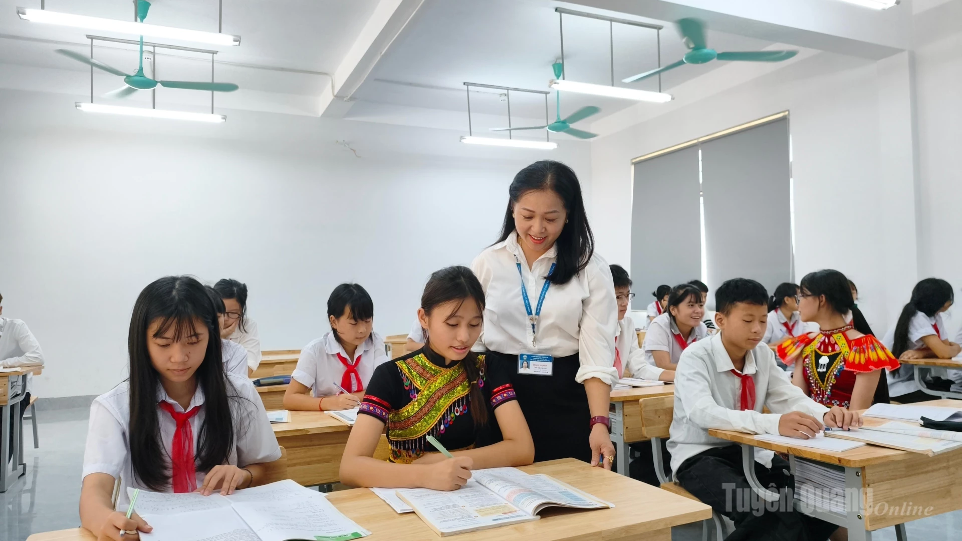 Cô giáo ân cần hướng dẫn bài cho học sinh.