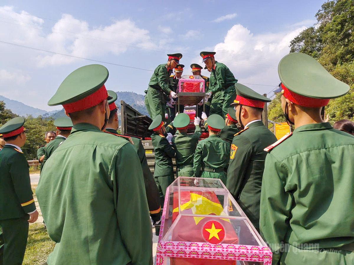 Lực lượng chức năng cẩn thận đưa hài cốt liệt sĩ lên các xe chuẩn bị di chuyển. Ảnh: Văn Long