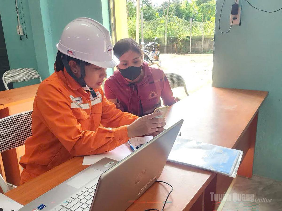 Nhân viên Điện lực Quang Bình phối hợp với chính quyền địa phương hướng dẫn người dân cài đặt app EVNCSKH.
