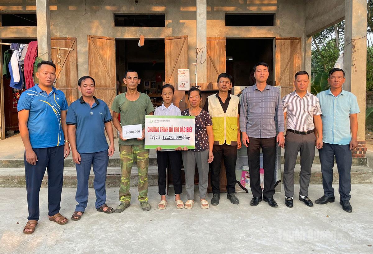 Đại diện tổ chức GNI và chính quyền địa phương trao hỗ trợ cho em Trần Thị Thêm.