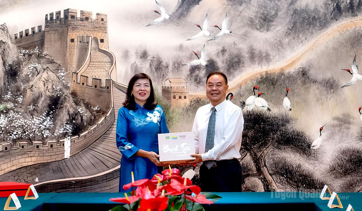 Đồng chí Phạm Thị Minh Xuân, Ủy viên Ban Thường vụ Tỉnh ủy, Phó Chủ tịch Hội đồng nhân dân tỉnh Tuyên Quang tặng quà đồng chí Vương Nghị, Chủ nhiệm Ban Thường vụ Nhân đại châu Văn Sơn.