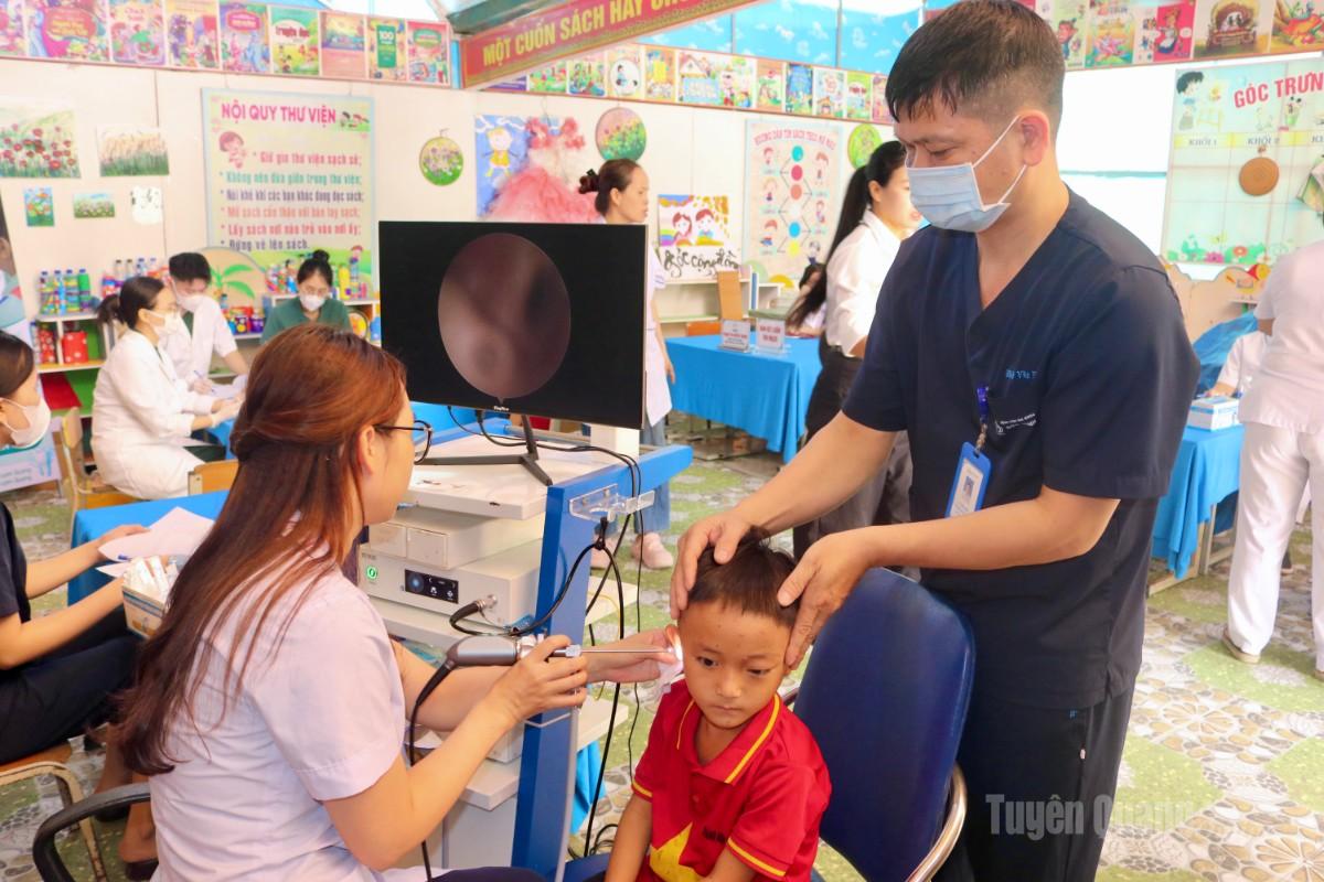 Bác sĩ khám tai mũi họng cho các em học sinh.