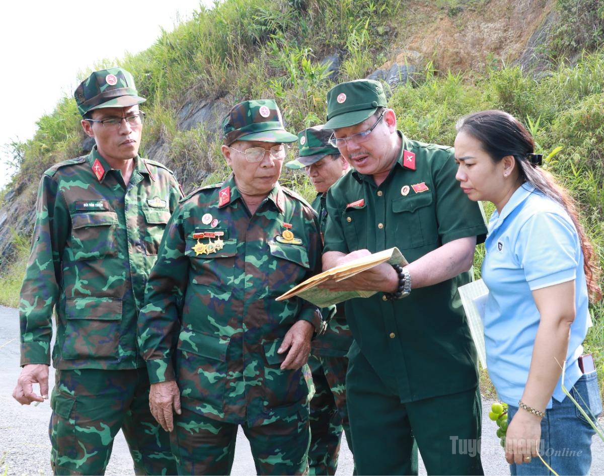 Các cựu chiến binh đối chiếu bản đồ với địa hình thực tế để xác định vị trí tìm kiếm hài cốt liệt sĩ.