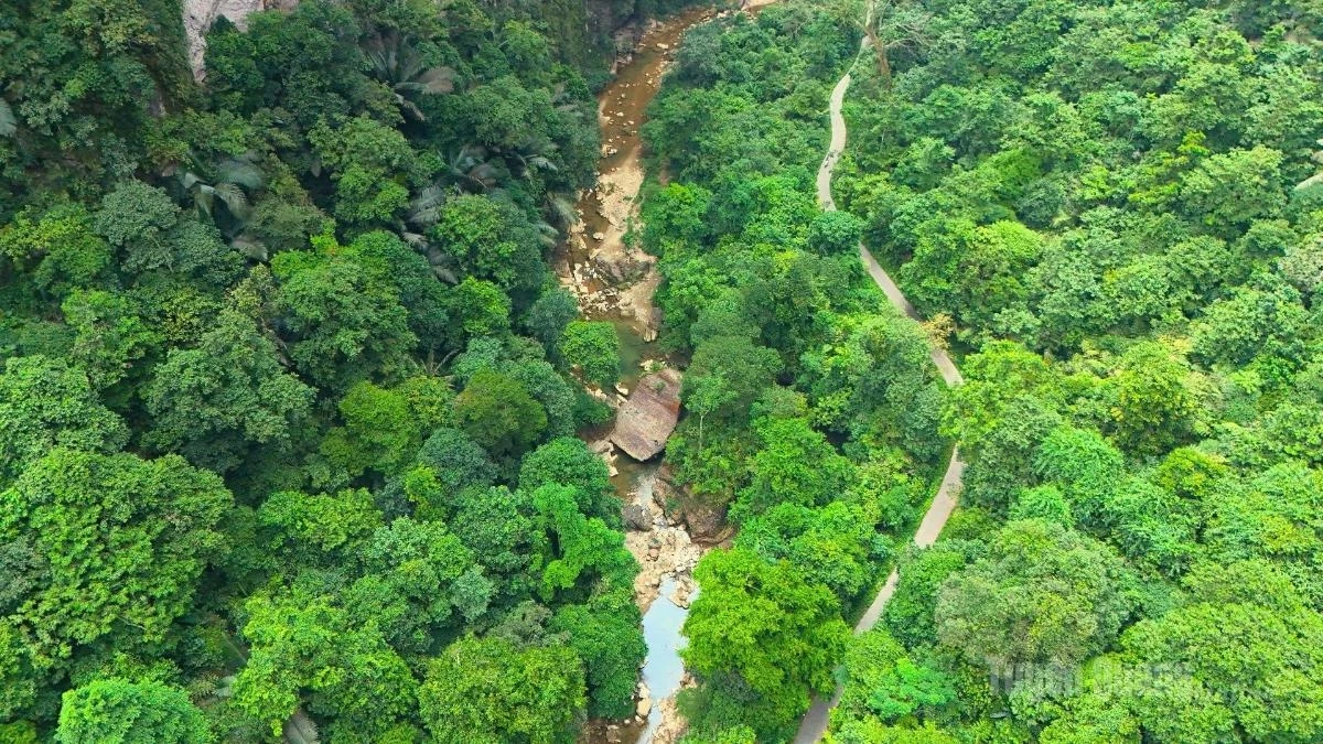 Towering, sheer cliffs rise on both sides, while a small stream winds its way alongside the only road leading to Lung Chang.