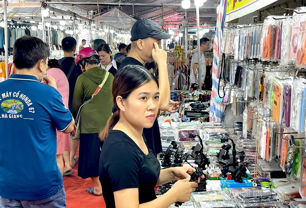 Người dân tham quan, chọn mua các sản phẩm phụ kiện điện thoại tại hội chợ.
