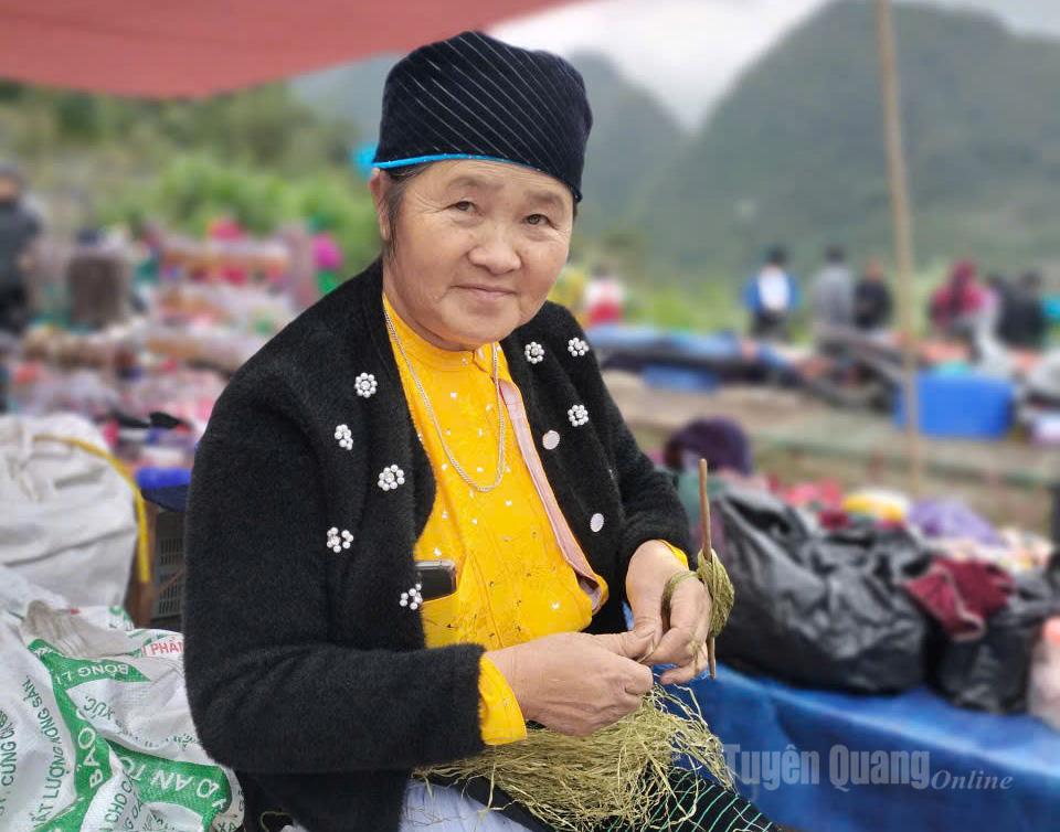A H’mong woman always carries a hemp thread in her hand, spinning even as she walks through the market.
