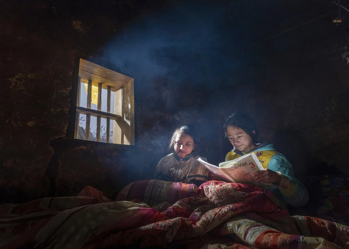 Every day, Vu Thi Dinh from Lao Xa village, Sa Phin commune, reads books to her sister Vu Thi Cho, who was born blind, helping her satisfy her thirst for learning.