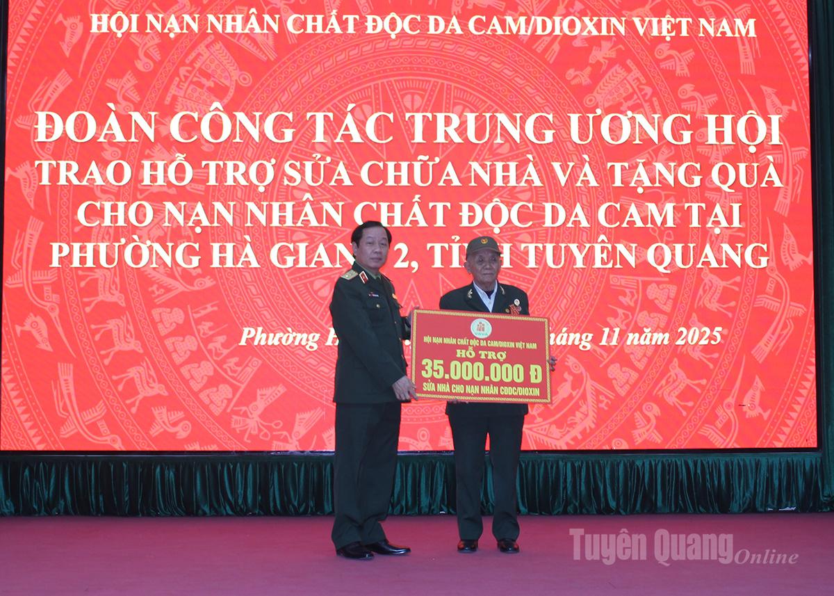 Trung tướng Nguyễn Hữu Chính, Ủy viên Đoàn Chủ tịch Ủy ban MTTQ Việt Nam, Chủ tịch Hội Nạn nhân chất độc da cam/dioxin Việt Nam trao kinh phí hỗ trợ sửa chữa nhà ở nạn nhân chất độc da cam/dioxin tại phường Hà Giang 2.