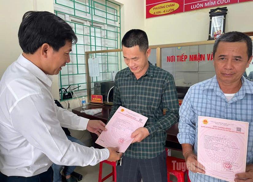 Lãnh đạo xã Tân Mỹ trao giấy chứng nhận quyền sử dụng đất lần đầu cho người dân.