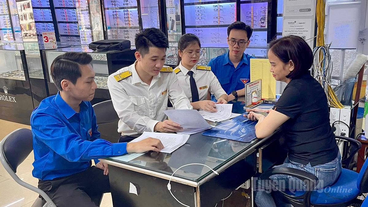 Công chức Thuế Cơ sở 6 tỉnh Tuyên Quang tuyên truyền, hỗ trợ trực tiếp hộ kinh doanh chuyển đổi từ thuế khoán sang kê khai. Ảnh: Thúy Nga