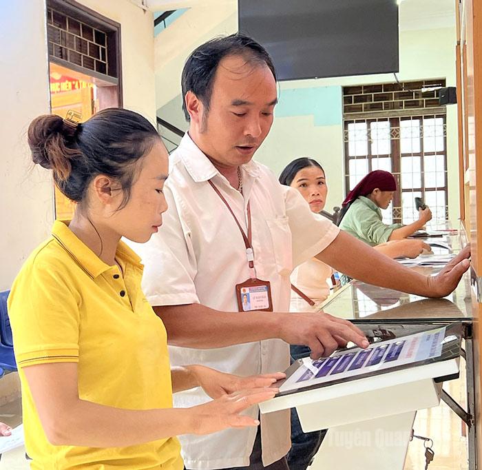 Công chức Trung tâm Phục vụ hành chính công xã Quản Bạ hướng dẫn người dân thao tác, đăng ký giải quyết thủ tục hành chính.