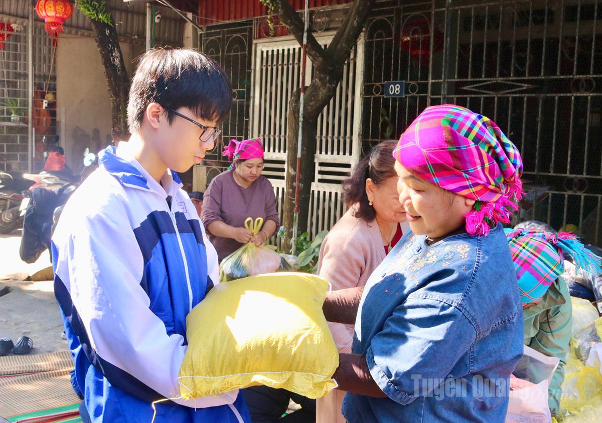 Tran Bich Ngoc (Residential Group 7, Minh Khai, Ha Giang 2 Ward) receives donated items, supporting the effort to deliver 1,000 banh chung gu that she voluntarily helped prepare.