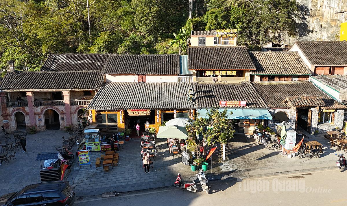 Ancient yin-yang–tiled roofs rest peacefully at the foot of overlapping cat-ear rocky mountains, creating a picturesque, poetic landscape.