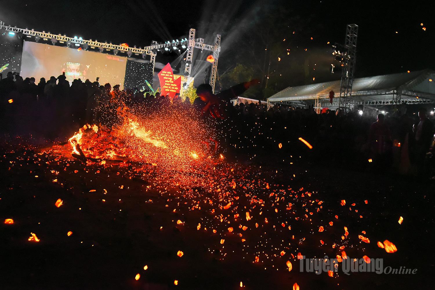 The fire dancers spin and dance atop the blazing ember pit amid cheers from locals and visitors.