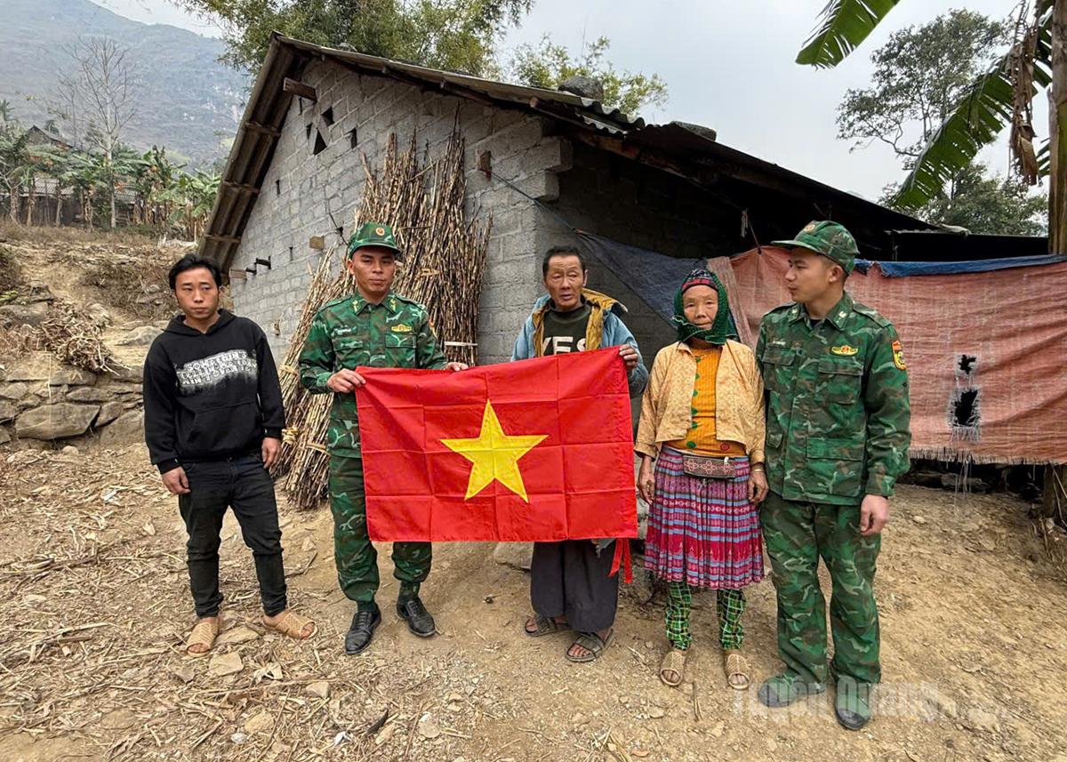 Officers and soldiers of Son Vi Border Guard Station present national flags to people in the border area.