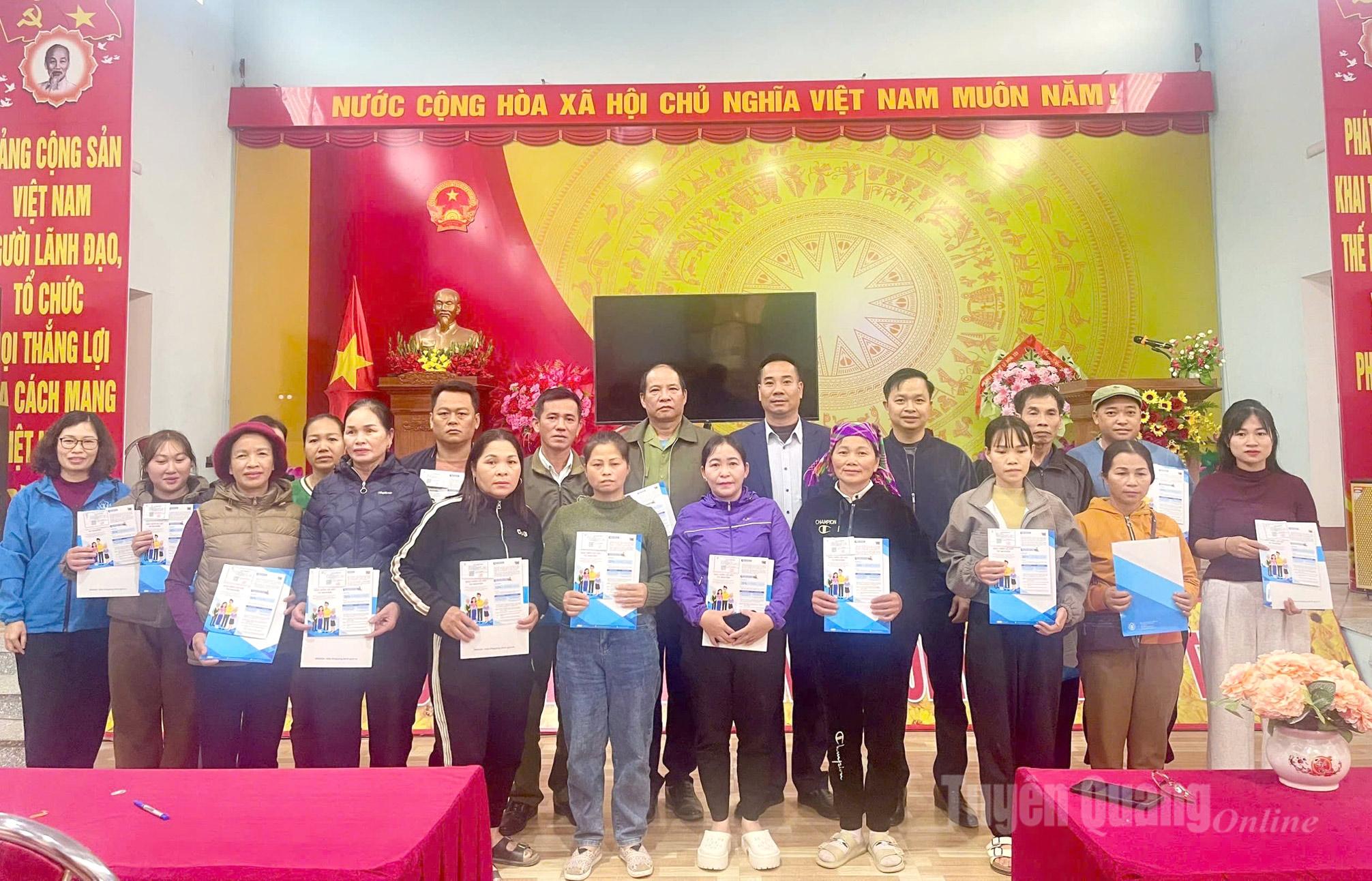 Đại diện BHXH Khu vực Bắc Quang và xã Đồng Yên trao thẻ BHYT cho người dân
