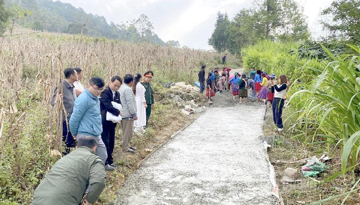 Nhóm hộ Khóm Tre, thôn Mon Vải làm đường giao thông từ nguồn xi măng được hỗ trợ.