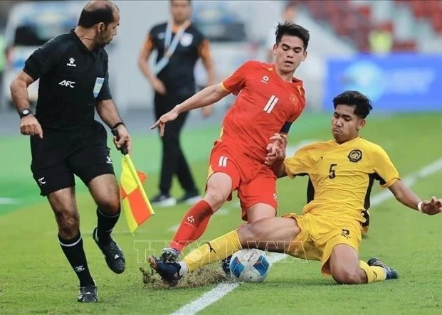 A U22 Malaysia player strives to stop Khuat Van Khang’s dribble. (Photo: VNA)