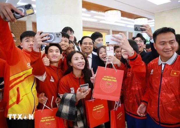 Prime Minister Pham Minh Chinh (central) and students who win prizes at international competitions in 2025. (Photo: VNA)