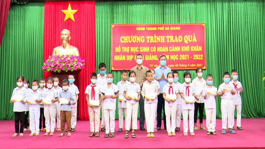 Lãnh đạo UBND thành phố trao quà cho các em có hoàn cảnh khó khăn.