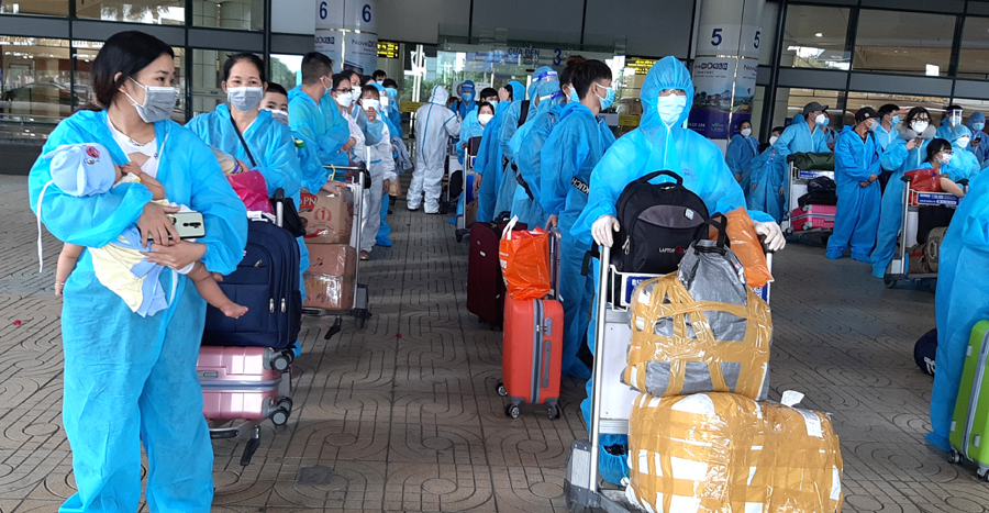 Sau khi xuống máy bay, các công dân xếp hàng chờ di chuyển về địa phương theo kế hoạch. Ảnh: CTV