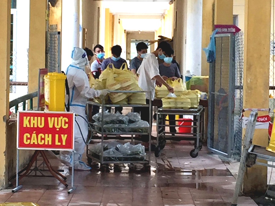 Những suất cơm nóng hổi vận chuyển đến nơi qui định và được cán bộ y tế trao cho từng người.