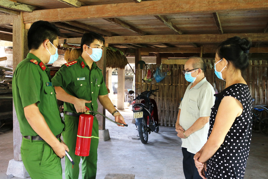  Cán bộ Phòng Cảnh sát PCCC và CNCH Công an tỉnh hướng dẫn người dân xã Phương Thiện (thành phố Hà Giang) cách sử dụng bình chữa cháy.