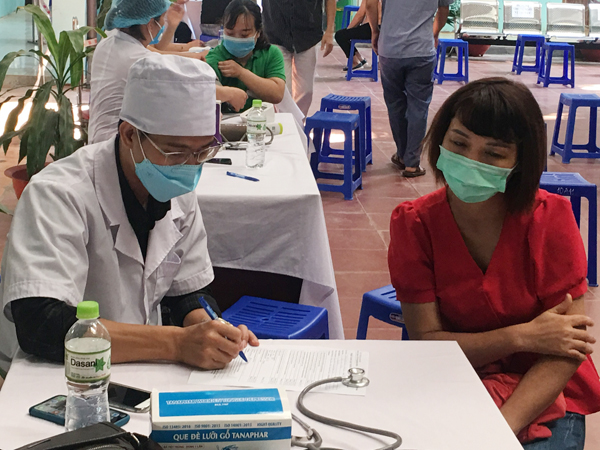 Lực lượng y tế thành phố kiểm tra sức khỏe người dân trước khi tiêm