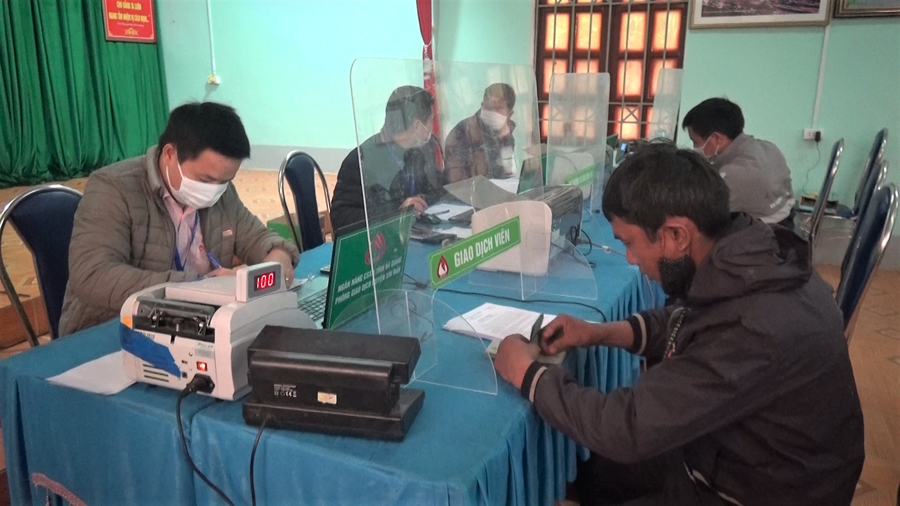 Cán bộ Phòng Giao dịch Ngân hàng CSXH huyện Xín Mần tiến hành các thủ tục giải ngân nguồn vốn vay cho các lao động trở về từ vùng dịch tại điểm giao dịch xã Nàn Ma.
