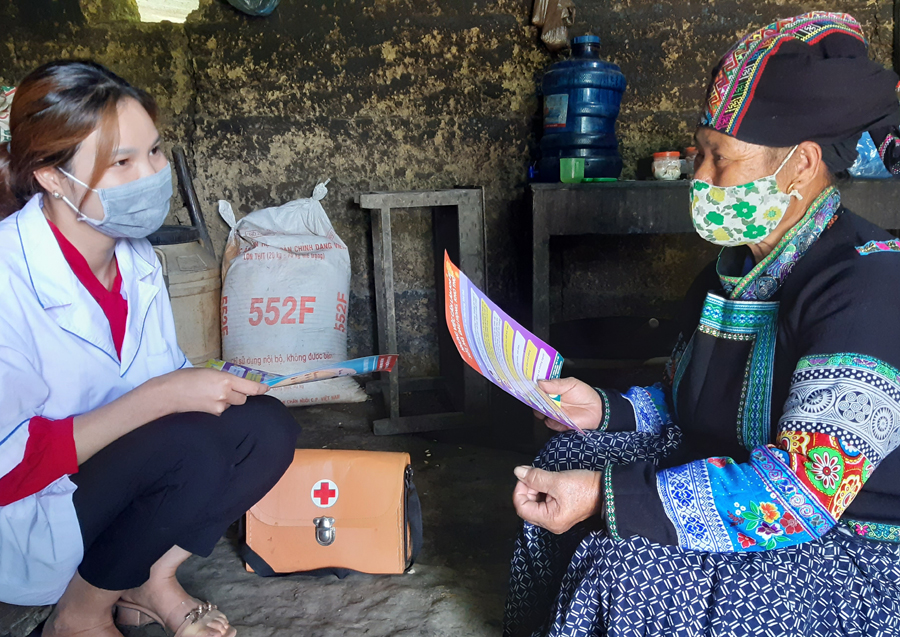 Cán bộ Trạm Y tế xã Quyết Tiến (Quản Bạ) tuyên truyền phòng, chống dịch bệnh Covid -19 tới người dân bằng các hình ảnh minh họa dễ hiểu.