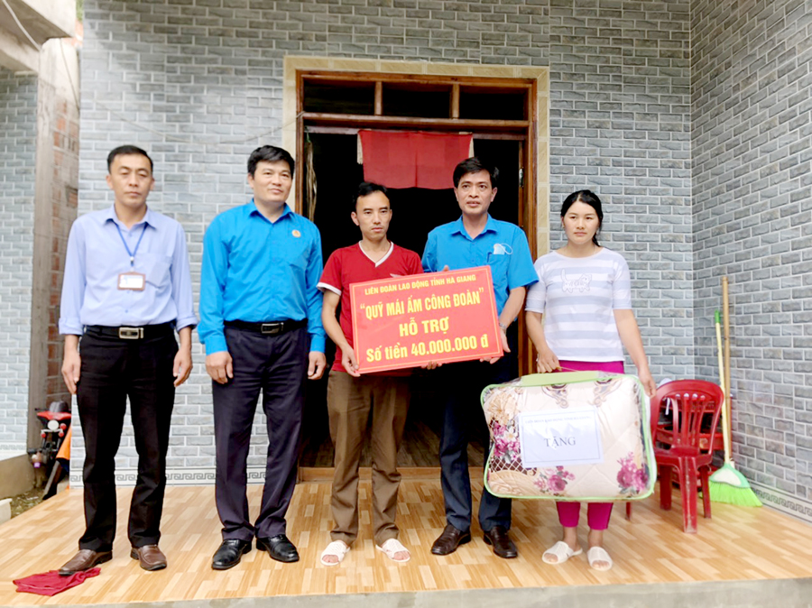 Lãnh đạo Liên đoàn Lao động tỉnh trao tiền hỗ trợ xây dựng “Mái ấm Công đoàn” cho gia đình anh Vừ Mí Dình, thị trấn Phố Bảng (Đồng Văn).       Ảnh: Tư liệu