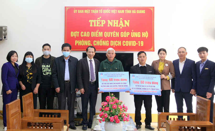 Đại diện 2 gia đình người có công tiếp nhận kinh phí hỗ trợ xây dựng nhà ở.