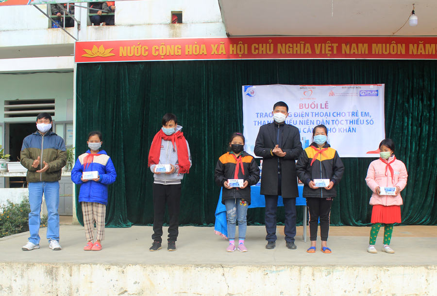 Đại diện Văn phòng Plan Hà Giang và lãnh đạo xã Giàng Chu Phìn trao điện thoại thông minh cho học sinh trường THCS Giàng Chu Phìn.