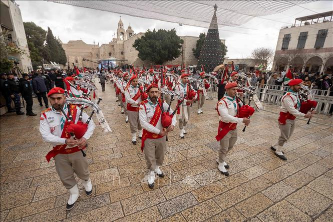 Người dân biểu diễn mừng Giáng sinh bên ngoài Nhà thờ Giáng sinh tại Bethlehem, Bờ Tây, ngày 24/12/2021.