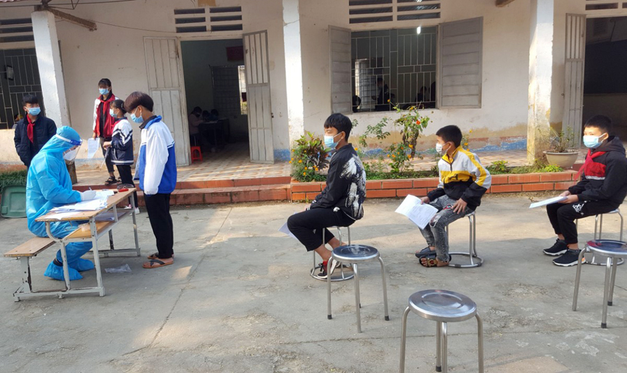 Các em học sinh lấy mẫu xét nghiệm khi quay trở lại trường học.